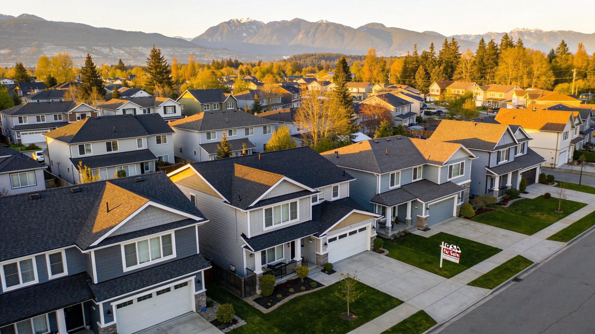 Aerial view of Surrey BC suburban neighborhood with townhouses and single-family homes in warm afternoon light